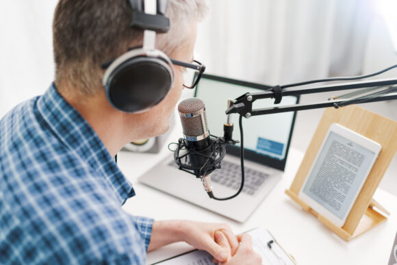 Man speaking into podcast microphone.