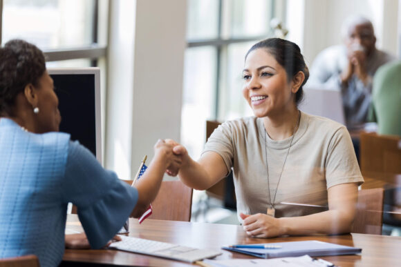 Veteran shaking hands with a loan officer while working through the VA loan process